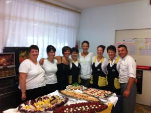 a group of people standing in front of a table with food at Hotel Mimosa in Lignano Sabbiadoro