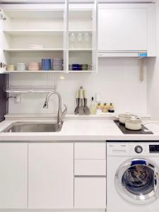 a white kitchen with a sink and a dishwasher at 2Room Jamsil lotteworld Kspo dome Olympic Park 2Queenbed in Seoul