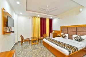Habitación de hotel con cama y TV en Hill Pine View en Dharamshala