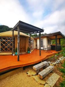 una casa con una gran terraza de madera en Petal Creek Farm en Tarakohe