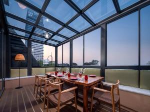 a dining room with a table and chairs and windows at Langham Place Guangzhou - Walking distance to Canton Fair in Guangzhou