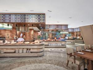 a restaurant with a counter with a chef preparing food at Langham Place Guangzhou - Walking distance to Canton Fair in Guangzhou