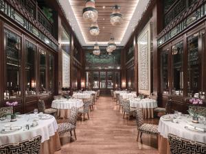 a dining room with white tables and chairs at Langham Place Guangzhou - Walking distance to Canton Fair in Guangzhou