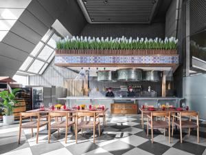 a restaurant with wooden tables and chairs and a kitchen at Langham Place Guangzhou - Walking distance to Canton Fair in Guangzhou