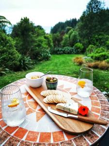 una mesa con una bandeja de queso y copas de vino en Petal Creek Farm, en Tarakohe