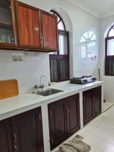 a kitchen with wooden cabinets and a sink in it at Home Stay Boutique Zanzibar in Stone Town