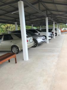 un grupo de autos estacionados en un estacionamiento en Meena Resort en Chanthaburi