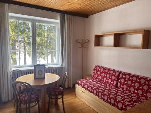 a living room with a red couch and a table at Residence Grand Hotel Carezza in Nova Levante