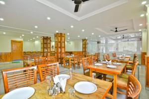 comedor con mesas y sillas de madera en Hill Pine View en Dharamshala