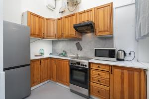 uma cozinha com armários de madeira e um frigorífico branco em Park Strzelecki Two-Level Apartment em Cracóvia