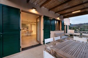 a patio with green sliding doors and a table and chairs at Borgo Isasco in Finale Ligure