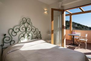 a bedroom with a bed and a balcony with a table at Borgo Isasco in Finale Ligure +87 photos
