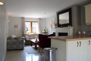 eine Küche und ein Wohnzimmer mit einem Sofa und einem Tisch in der Unterkunft Cosy Holidayhomes Kerry in Kenmare