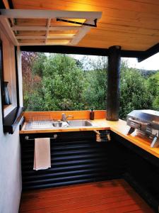 an outdoor kitchen with a sink and a grill at Petal Creek Farm in Tarakohe