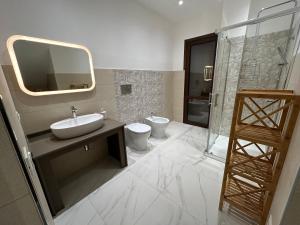 ein Badezimmer mit einem Waschbecken, einem WC und einem Spiegel in der Unterkunft Ficodindia in Pozzallo