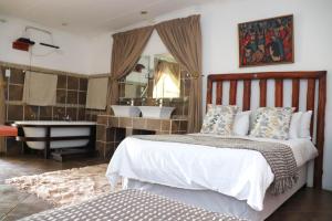 a bedroom with a bed and a tub and a sink at Umnotho We Afrika House in Bronkhorstspruit