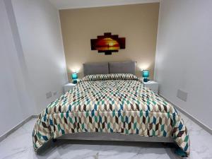 ein Schlafzimmer mit einem Bett und zwei Nachttischen in der Unterkunft Ficodindia in Pozzallo