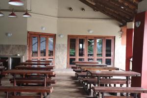 a row of wooden benches in a room with windows at Umnotho We Afrika House in Erasmus