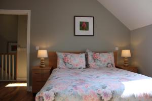 a bedroom with a bed with a floral bedspread and two lamps at Cosy Holidayhomes Kerry in Kenmare