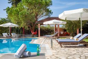 a swimming pool with two lounge chairs and umbrellas at Bella Villa Vasiliki in Litherés