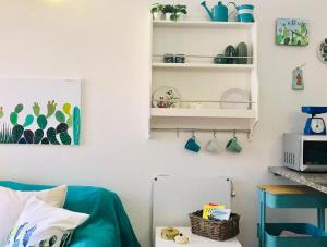 a living room with a blue couch and shelves at Grazioso appartamento con terrazzo in posizione centralissima a Sant'Antioco C135 in SantʼAntìoco