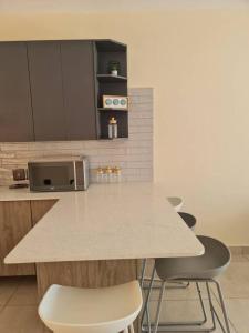 a kitchen with a table with chairs and a microwave at Cozy Apartment Jhb South in Johannesburg