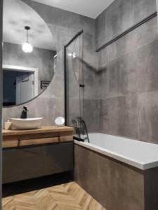 a bathroom with a tub and a sink and a mirror at Apartament Mieszkanie Noclegi Żywiec in Żywiec