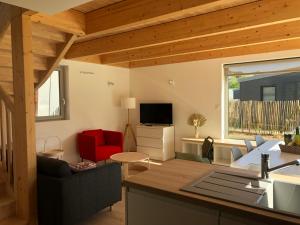 una cucina e un soggiorno con soffitti in legno di Les cabines du bout du monde - Cabine Duplex , votre maison de vacances de haut standing à Crozon a Crozon