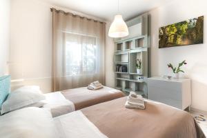a bedroom with two beds and a book shelf at Sorrento Central Flat in Sorrento