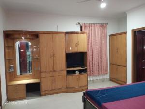 a large room with wooden cabinets and a tv at LOZZY HOMESTAY in Guwahati