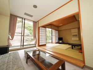 多武峰観光ホテル في Sakurai: غرفة معيشة مع طاولة وبيانو
