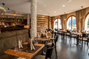 ein Restaurant mit Tischen und Stühlen und eine Bar in der Unterkunft Hotel Allegra in Zuoz