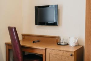 a room with a desk with a tv on the wall at CATHEDRAL HOTEL Self-check in in Vilnius
