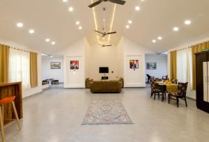 a living room with a ceiling fan and a dining room at Silver Farm Villa in Nashik