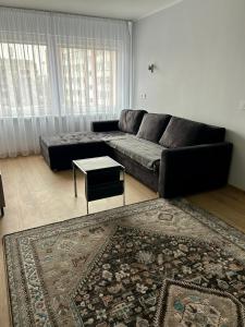 un soggiorno con divano nero e tappeto di BrightNest a Ventspils