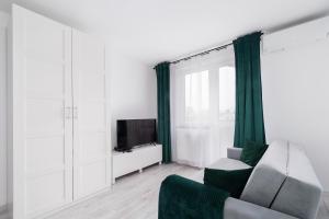a living room with a couch and a tv at Bella Casa Premium Apartment - 117A Kobierzynska in Krakow