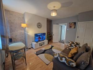 a living room with a couch and a tv at Executive 2-Bedroom House in Wallsend in Wallsend