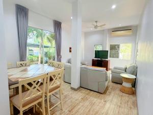 a living room with a table and a dining room at Rawai Valley Resort in Rawai Beach