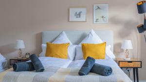 a bedroom with a white bed with yellow pillows at E&K Apartment kleine Bandstraße in Wuppertal