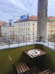 un tavolo e sedie su un balcone con vista sugli edifici di Saffron Apartment-Panoramic Balcony a Budapest