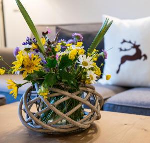a bouquet of flowers in a basket on a table at Zin Senfter Residence in San Candido