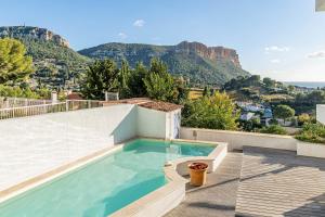 uma piscina no telhado de uma casa com montanhas em Les Restanques par Dodo à Cassis em Cassis