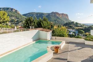 a swimming pool on the roof of a house with mountains at Les Restanques par Dodo à Cassis in Cassis