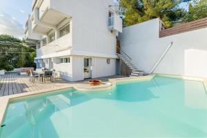 a swimming pool in front of a house at Les Restanques par Dodo à Cassis in Cassis