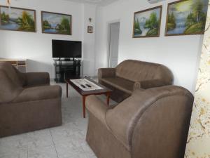 uma sala de estar com um sofá, uma cadeira e uma mesa em Halasi Szallashely em Hajdúszoboszló