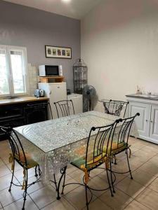 a kitchen with a table with chairs and a table and a table and chairsktop at Appart*Résidence piscine*Parking*3mn Centre Sarlat in Sarlat-la-Canéda +1 photo