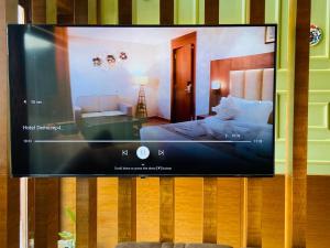 a flat screen tv hanging on a wall with a bedroom at HOTEL RAMTA CONTINENTAL in Patna