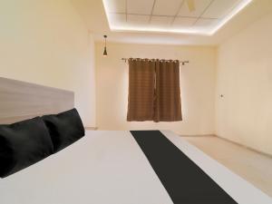 Habitación con cama y cortina en OYO Saubhagya Shri Resort en Hoshangābād