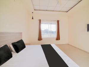 a room with a bed with black and white at OYO Saubhagya Shri Resort in Hoshangābād