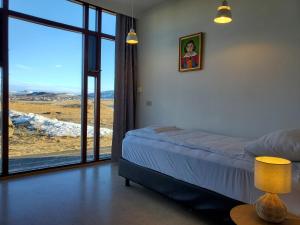 a bedroom with a bed and a large window at Víðines Guesthouse in Reykjavík